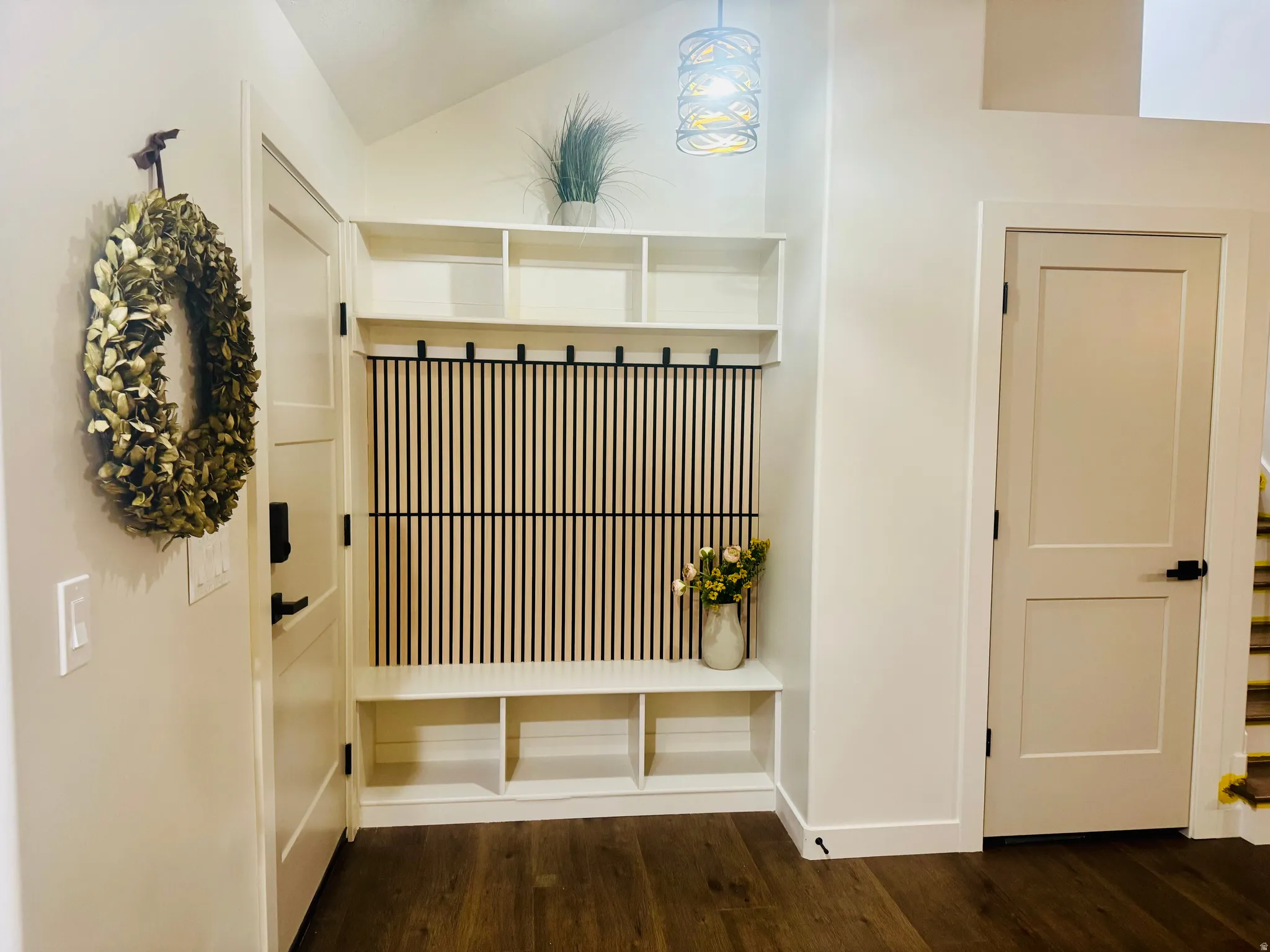 Entryway featuring built-in storage with a seating bench, open shelving, and coat hooks