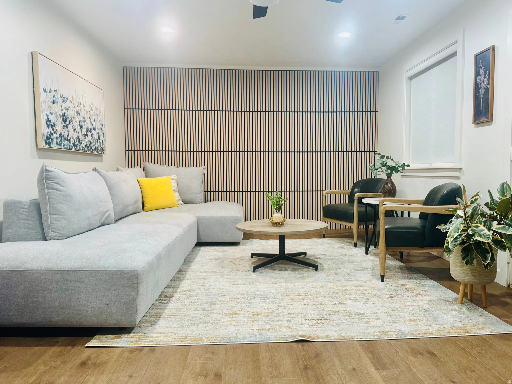 Living area featuring wood-finish flooring and a decorative slat wall accent