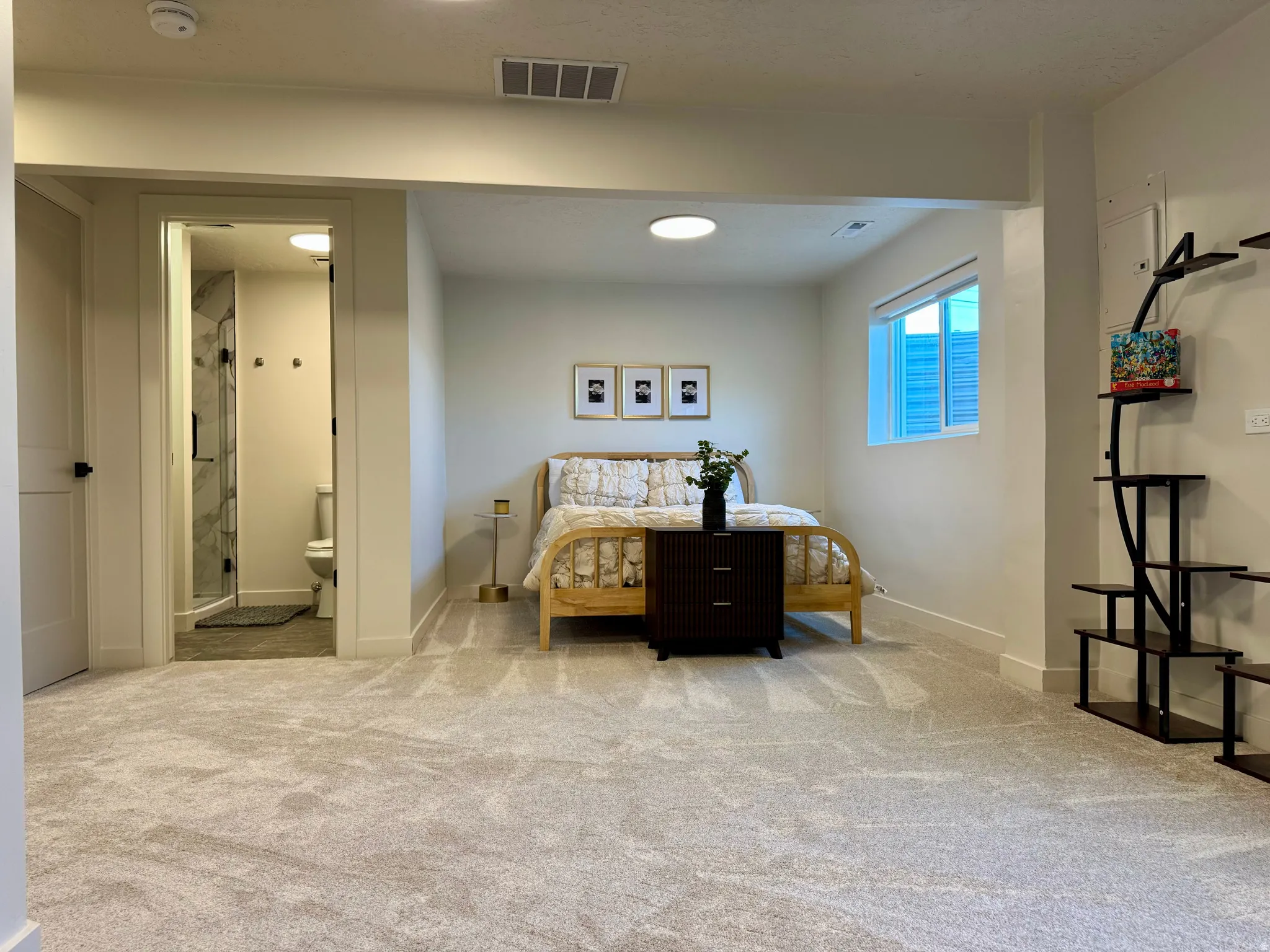 Carpeted room featuring a window with integrated blinds, recessed ceiling lighting, and an en-suite bathroom with a glass-enclosed shower and tiled walls