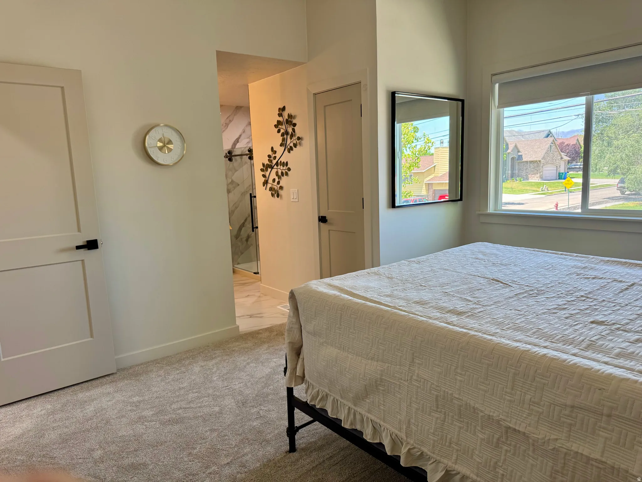 Carpeted bedroom with a large window, providing natural illumination