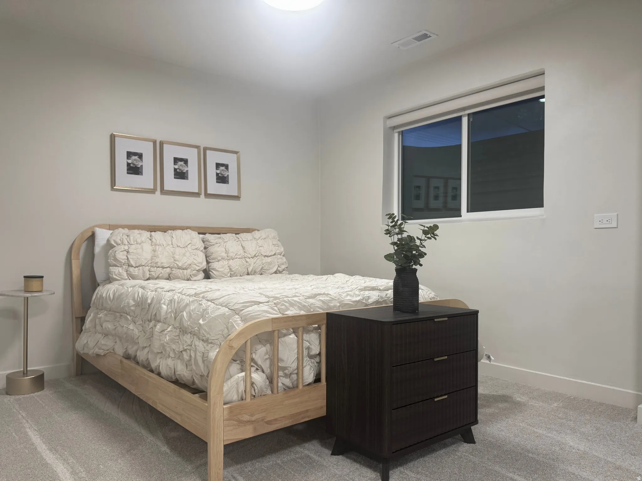Light-colored wall finishes complement the soft gray carpet flooring