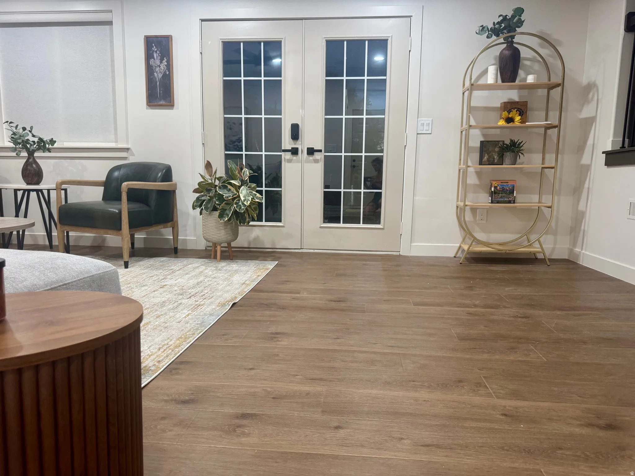 Wide plank wood-finish flooring extending throughout, featuring white baseboards
