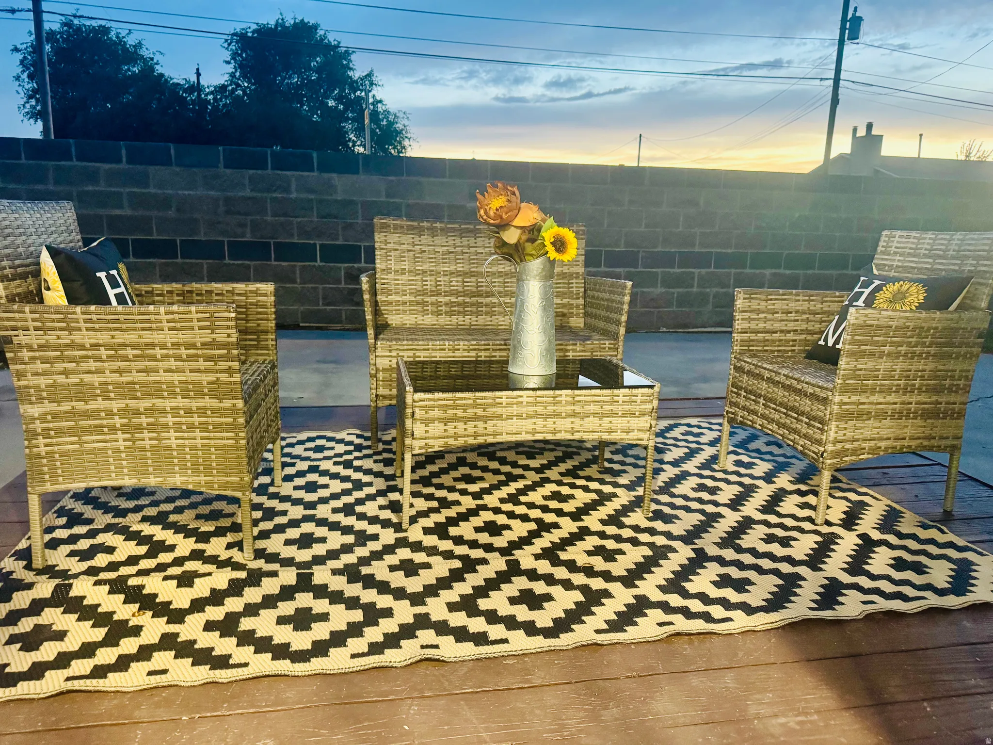 Outdoor patio featuring a black and cream geometric patterned rug on a wood-finish deck