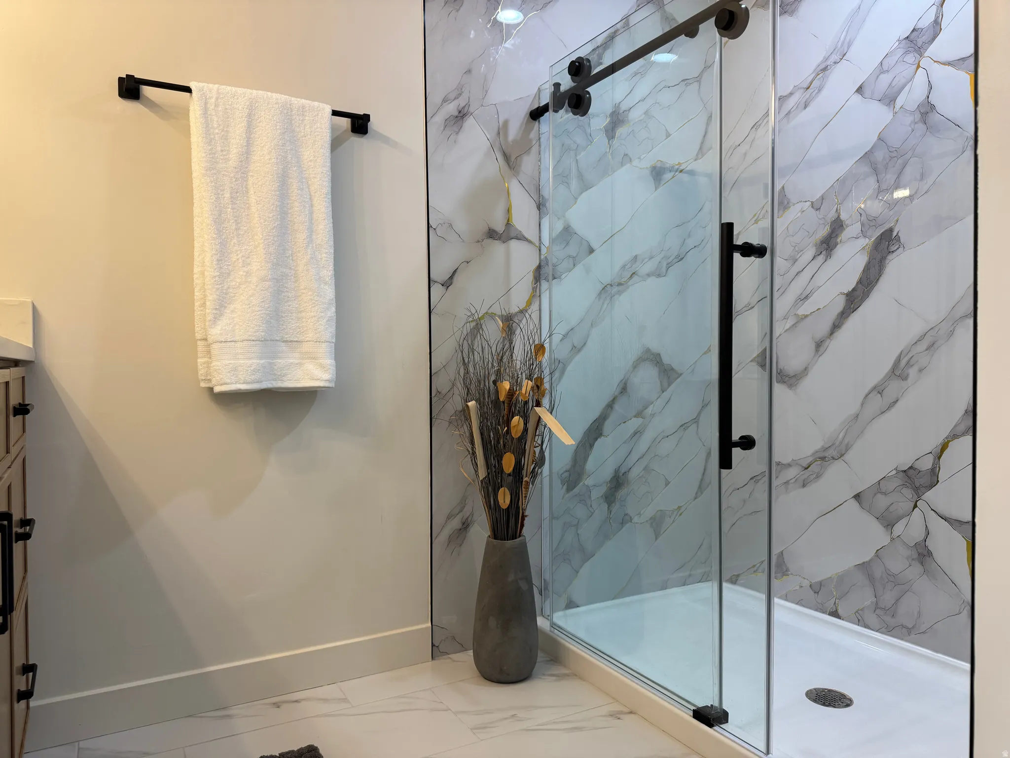 Contemporary shower enclosure featuring clear glass panels, matte black hardware, and patterned wall tile