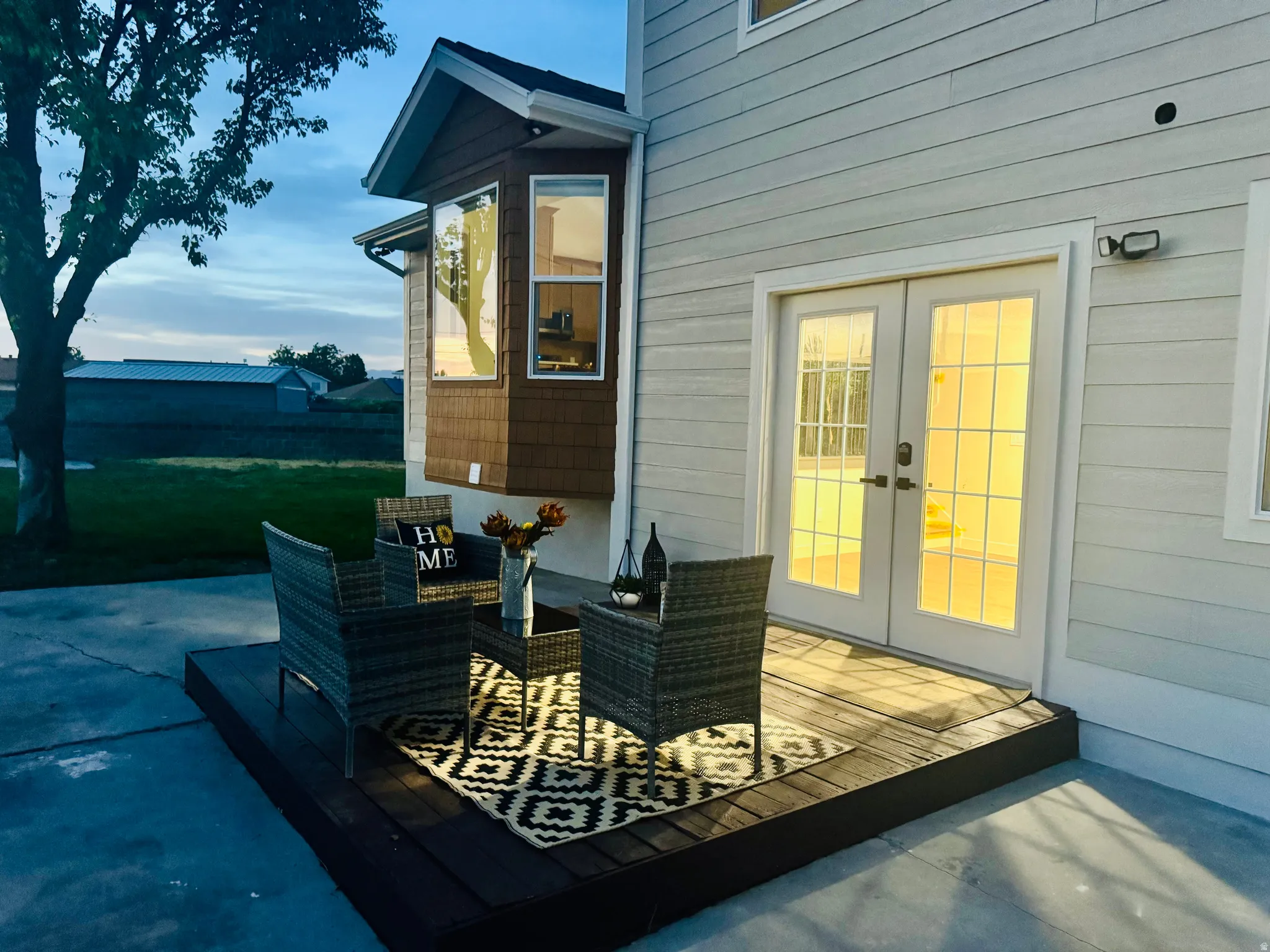 Exterior featuring light-colored horizontal siding, a bay window with shake siding, and a dark wood-finish deck
