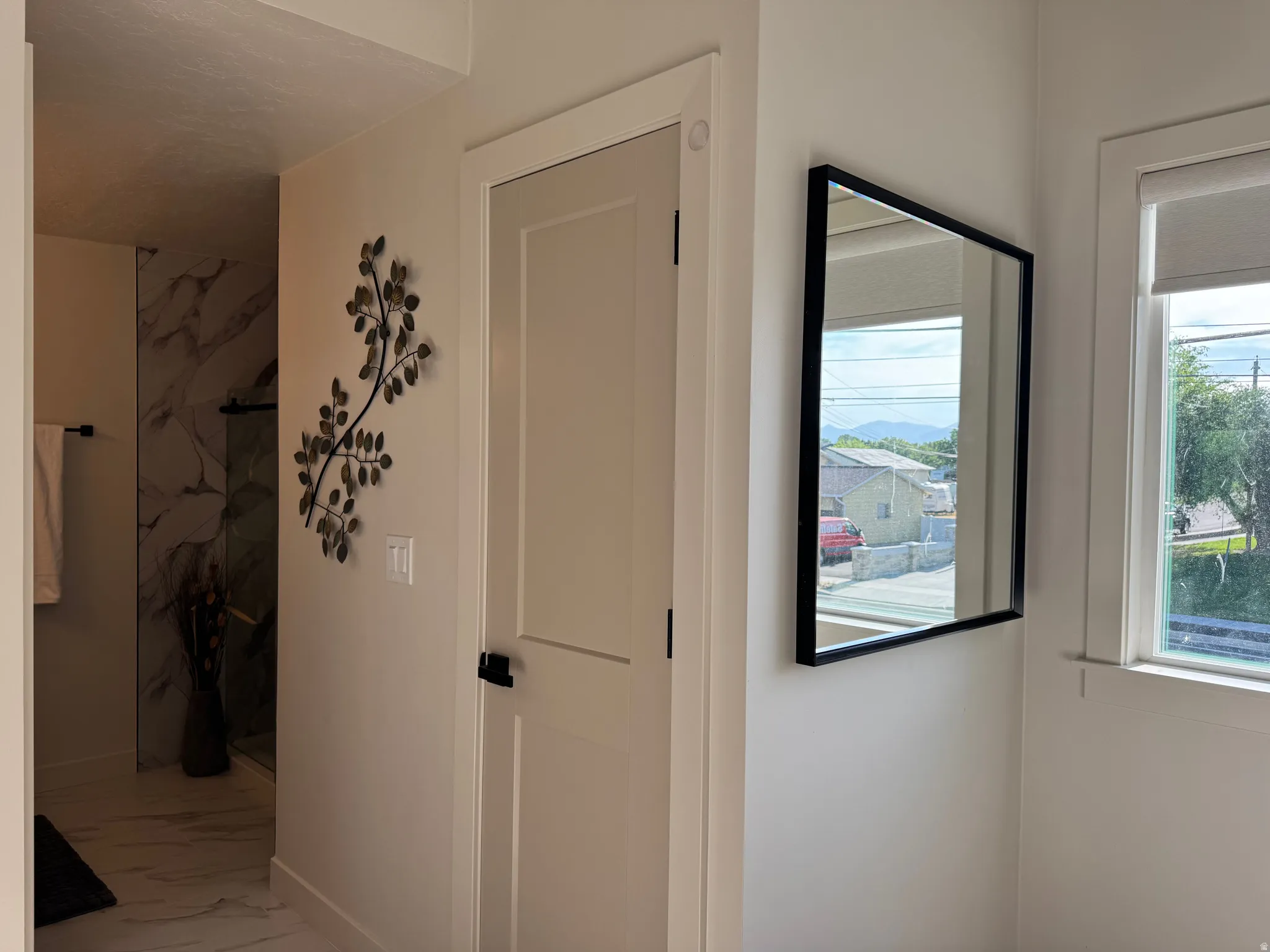 White interior door with black hardware, framed by light neutral walls