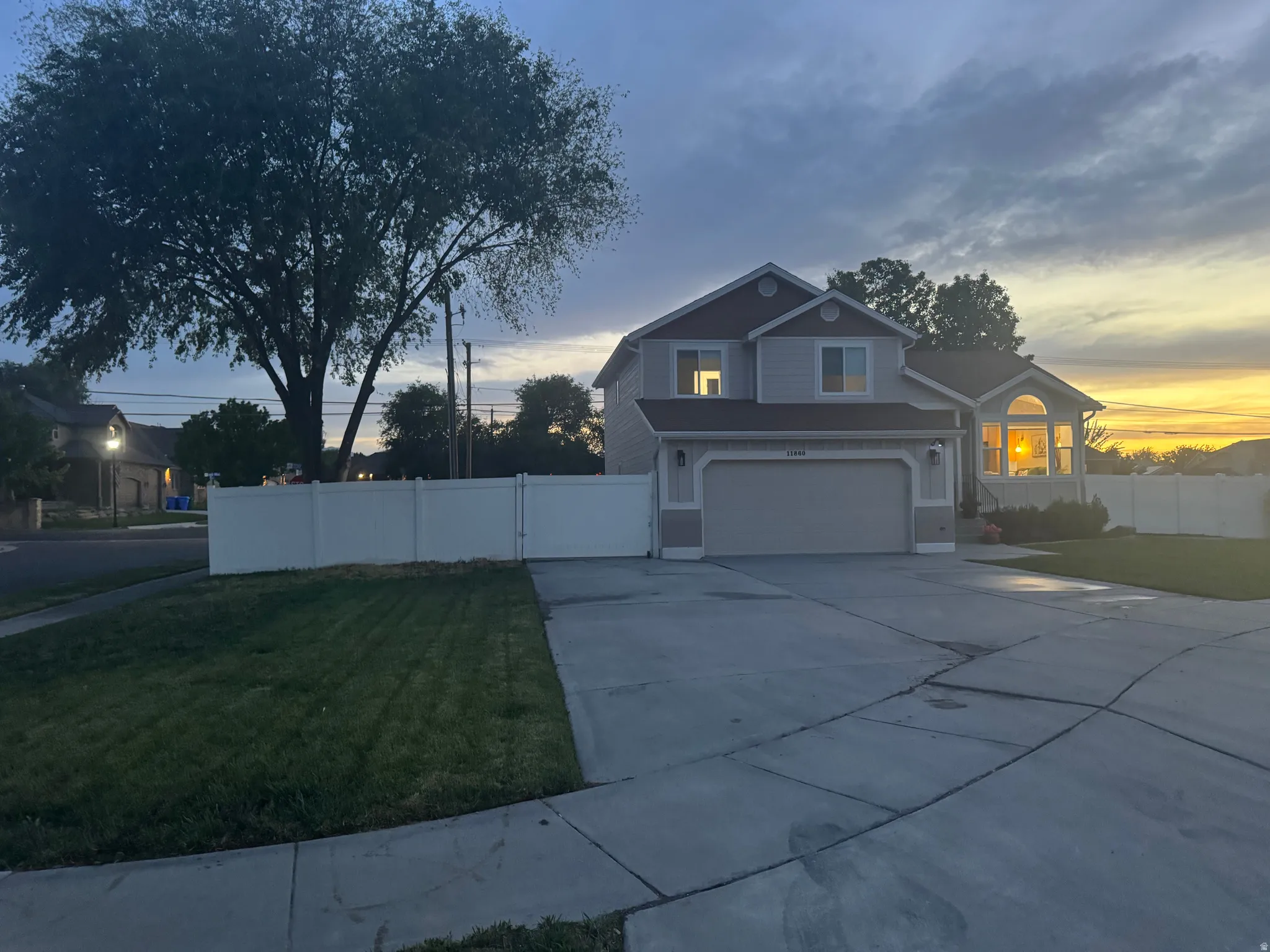 Two-story residence featuring light gray siding with dark gray trim accents and a two-car garage