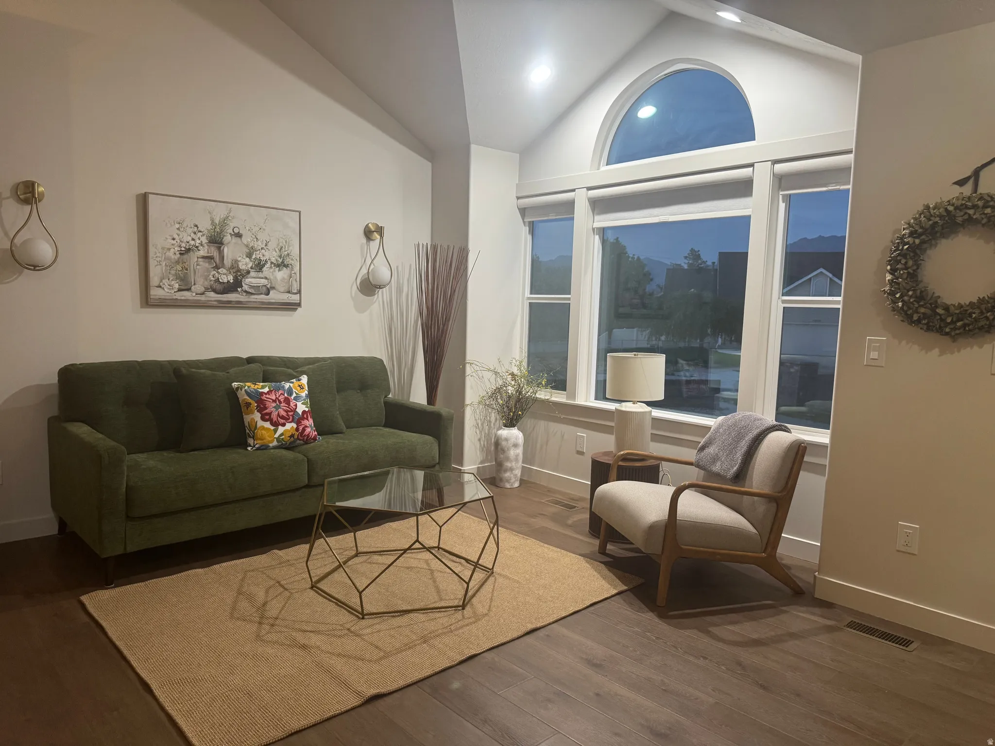 Spacious living area featuring vaulted ceilings and wood-finish flooring