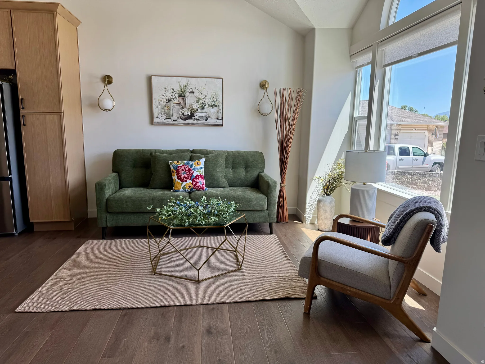 Spacious living area featuring wood-finish flooring and a vaulted ceiling