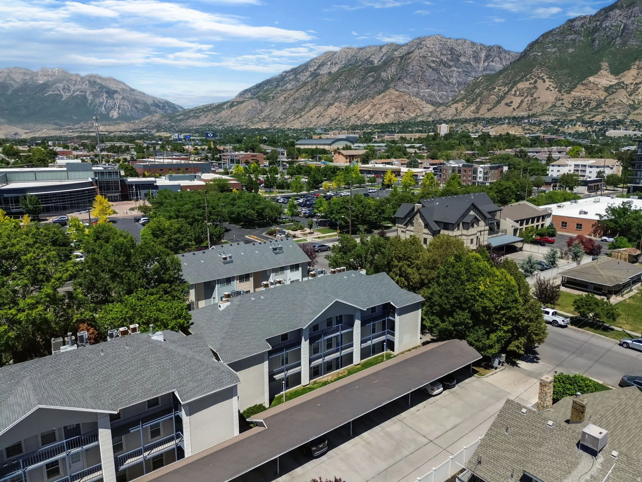 Multi-story residential buildings featuring grey shingle roofs and multiple balconies