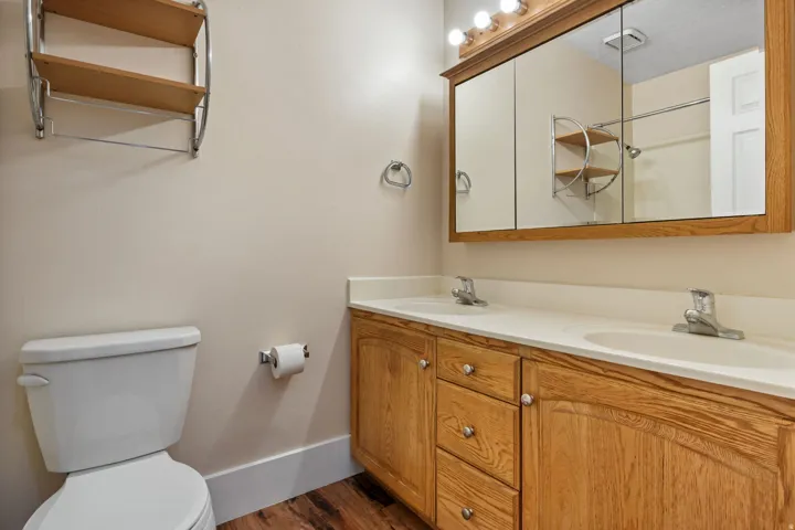 Bathroom featuring a dual vanity with light wood cabinetry, white countertops, and integrated sinks