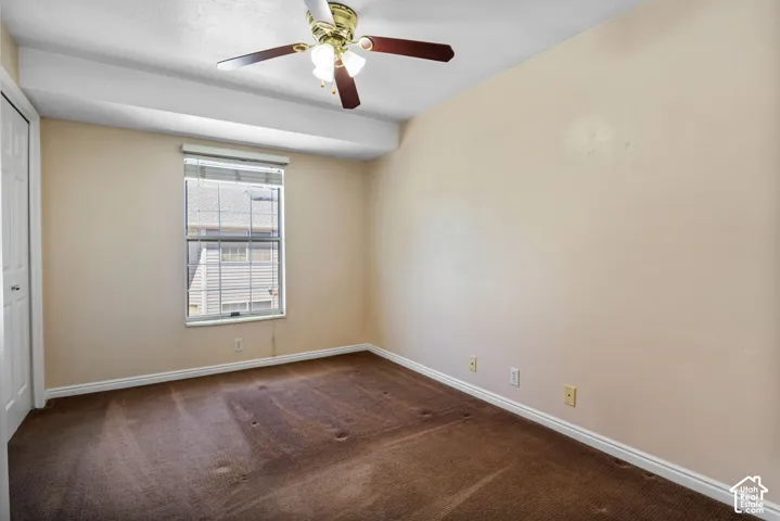 Room featuring wall-to-wall carpeting, neutral wall finishes, a window with horizontal blinds, and a ceiling fan with light fixture