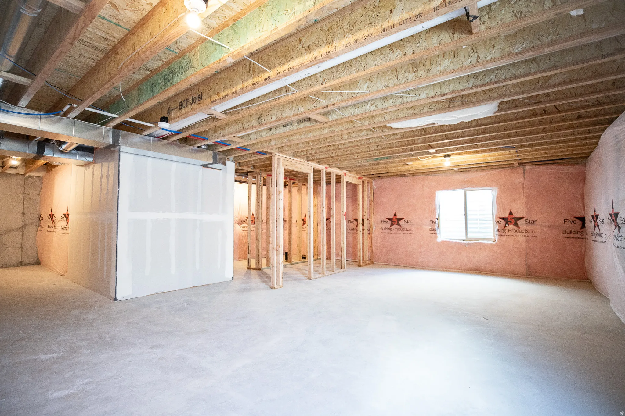 Unfinished basement with potential for large family/game room, a full bathroom and one bedroom with a storage area.