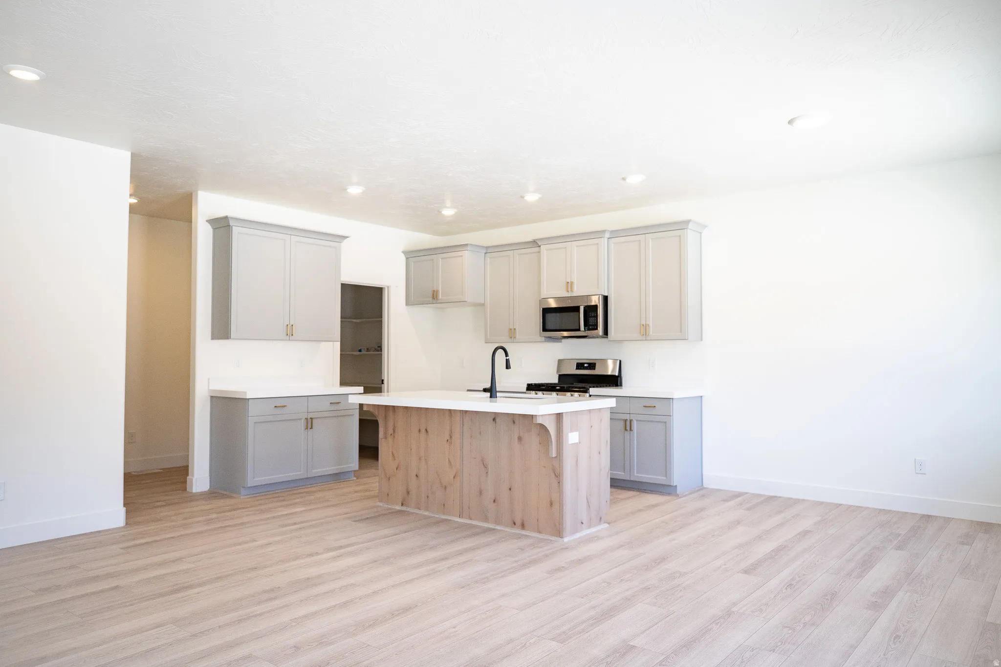 Great kitchen adjacent to dining area with large pantry, painted and stained wood cabinets, quartz slab countertops, 42" uppers, gas range, microwave, dishwasher and disposal.