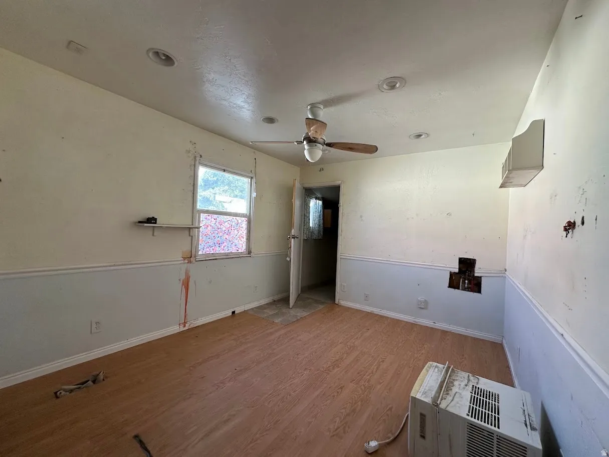 Room featuring wood-finish flooring, a ceiling fan, and recessed lighting
