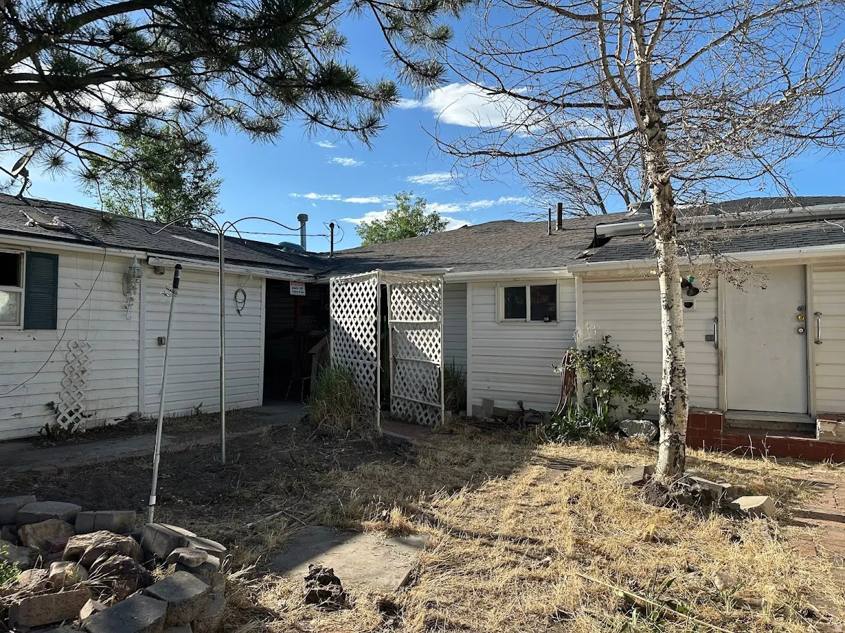 Exterior of the property featuring white siding and a dark shingle roof