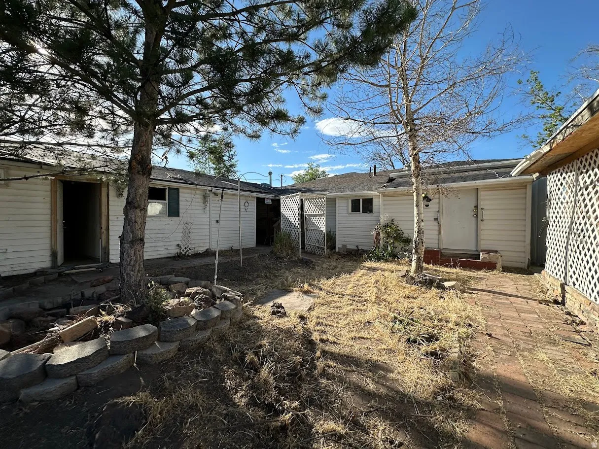 Enclosed yard area featuring multiple structures with white siding
