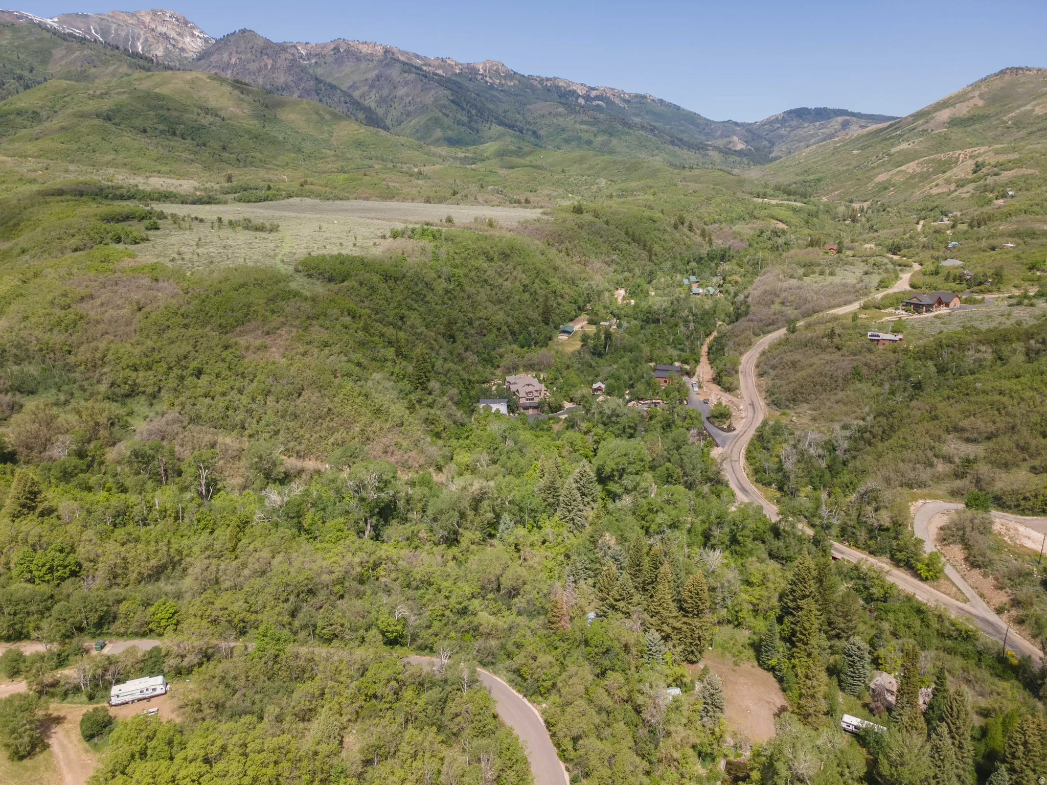 Mountainous landscape featuring extensive green foliage and visible roadways