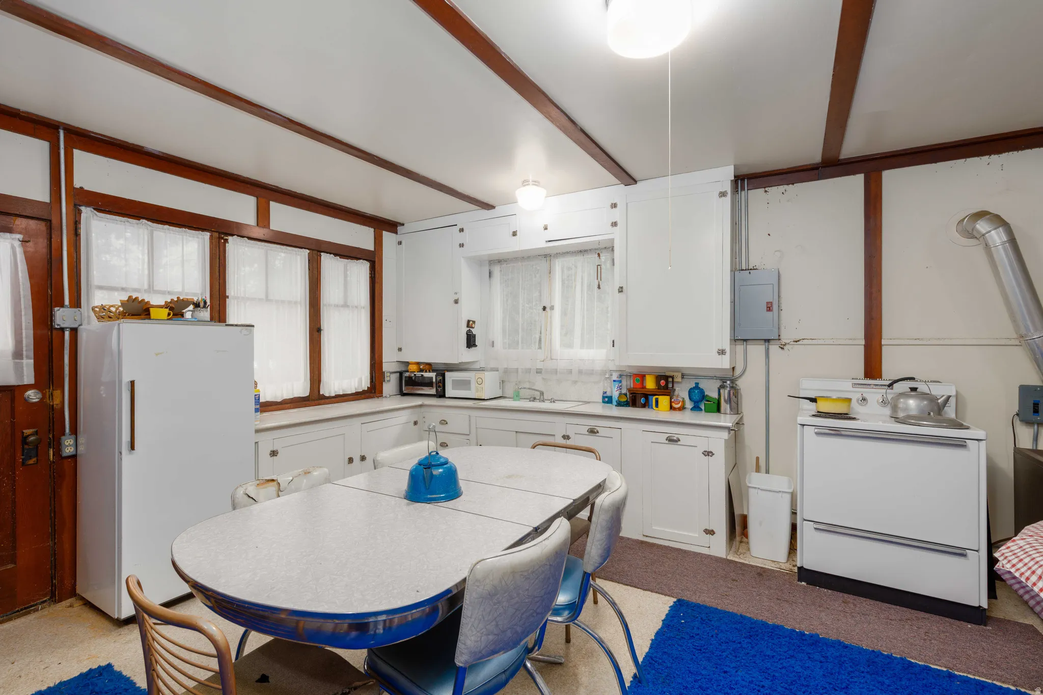 Kitchen area featuring white cabinetry, a built-in sink, and multiple windows