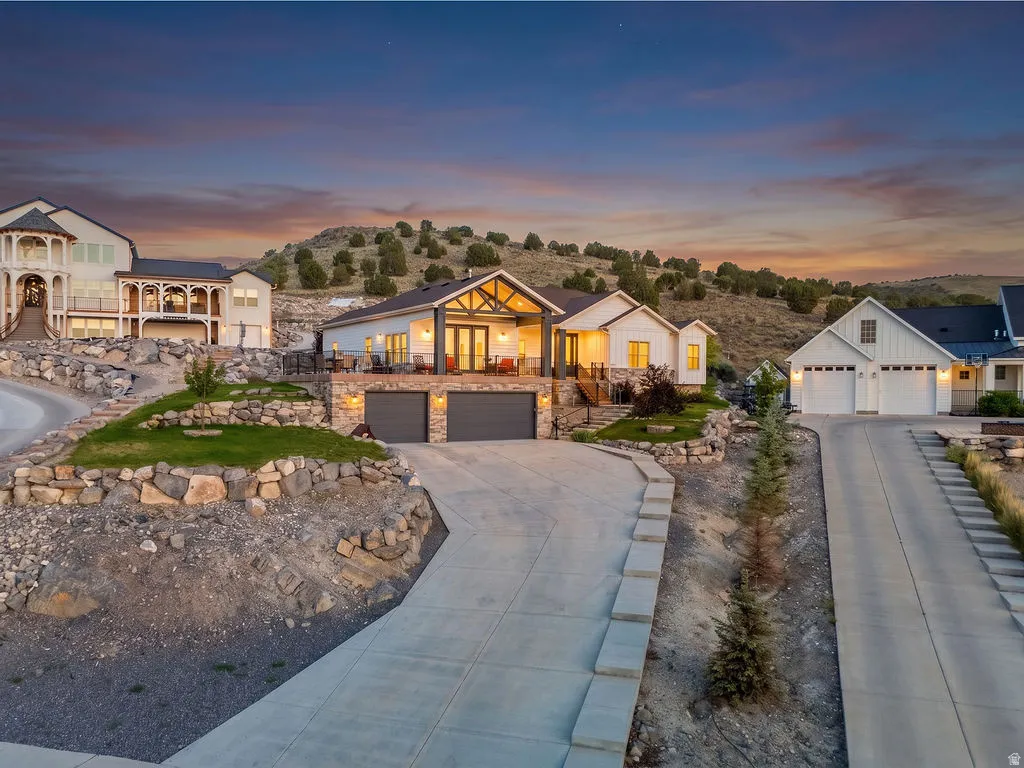 Modern architectural design featuring a prominent front porch with exposed beams, stone accents, and an attached two-car garage