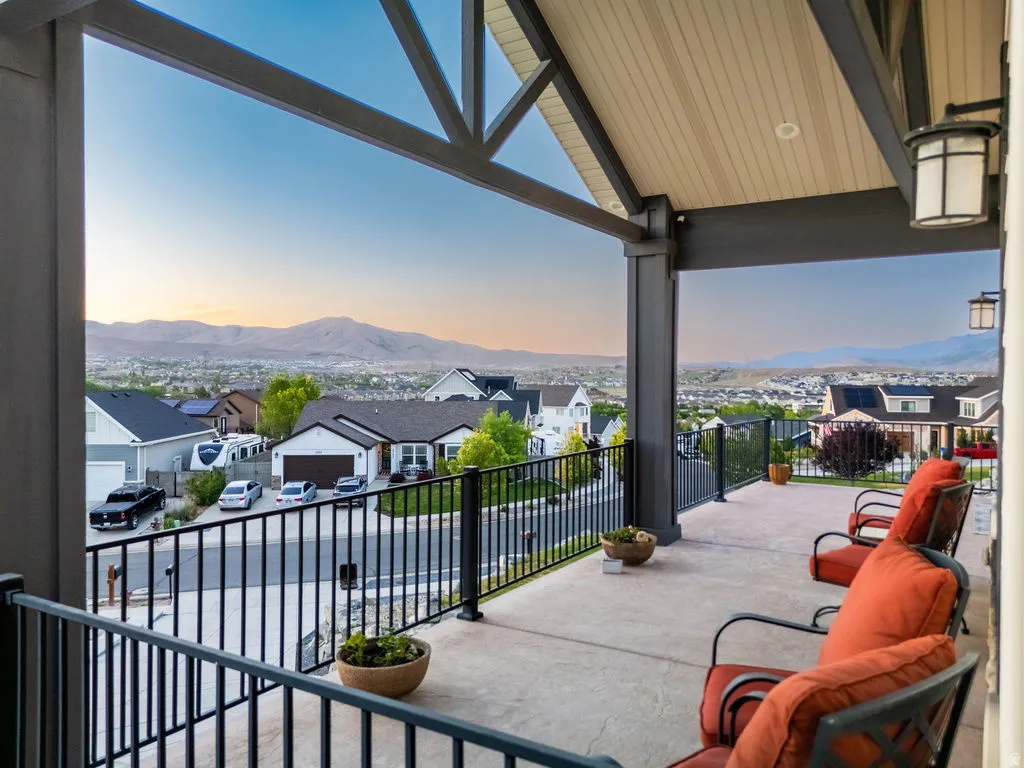 Spacious covered patio with concrete flooring and black metal railing