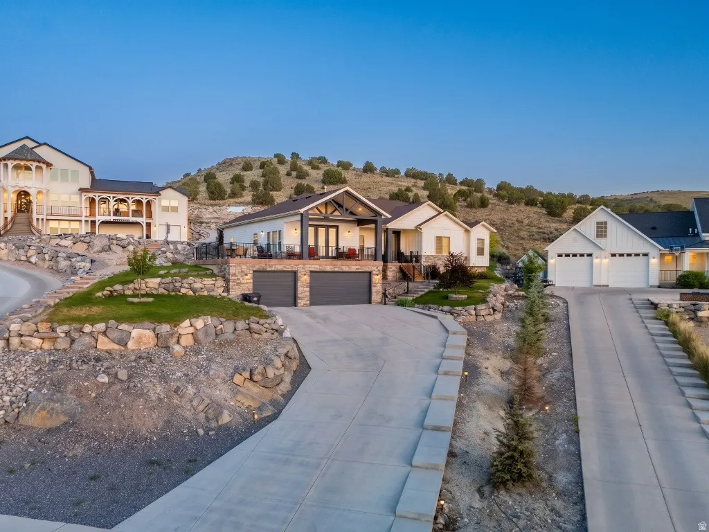 Contemporary hillside property with a two-car garage, stone facade, and a private balcony