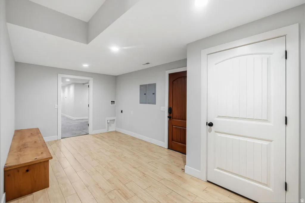 Spacious interior area featuring wood-finish flooring, light gray wall paint, and white trim