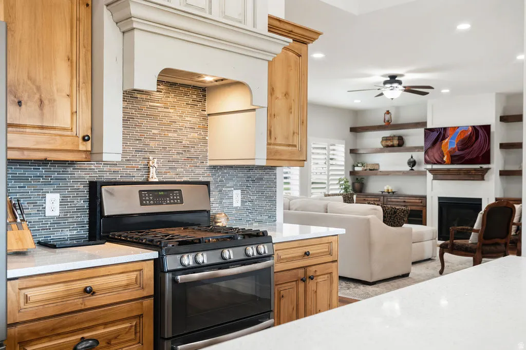 Stainless steel range with a tile backsplash and custom wood-finish cabinetry