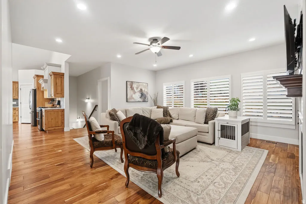 Spacious living area featuring wood-finish flooring, recessed lighting, and a ceiling fan