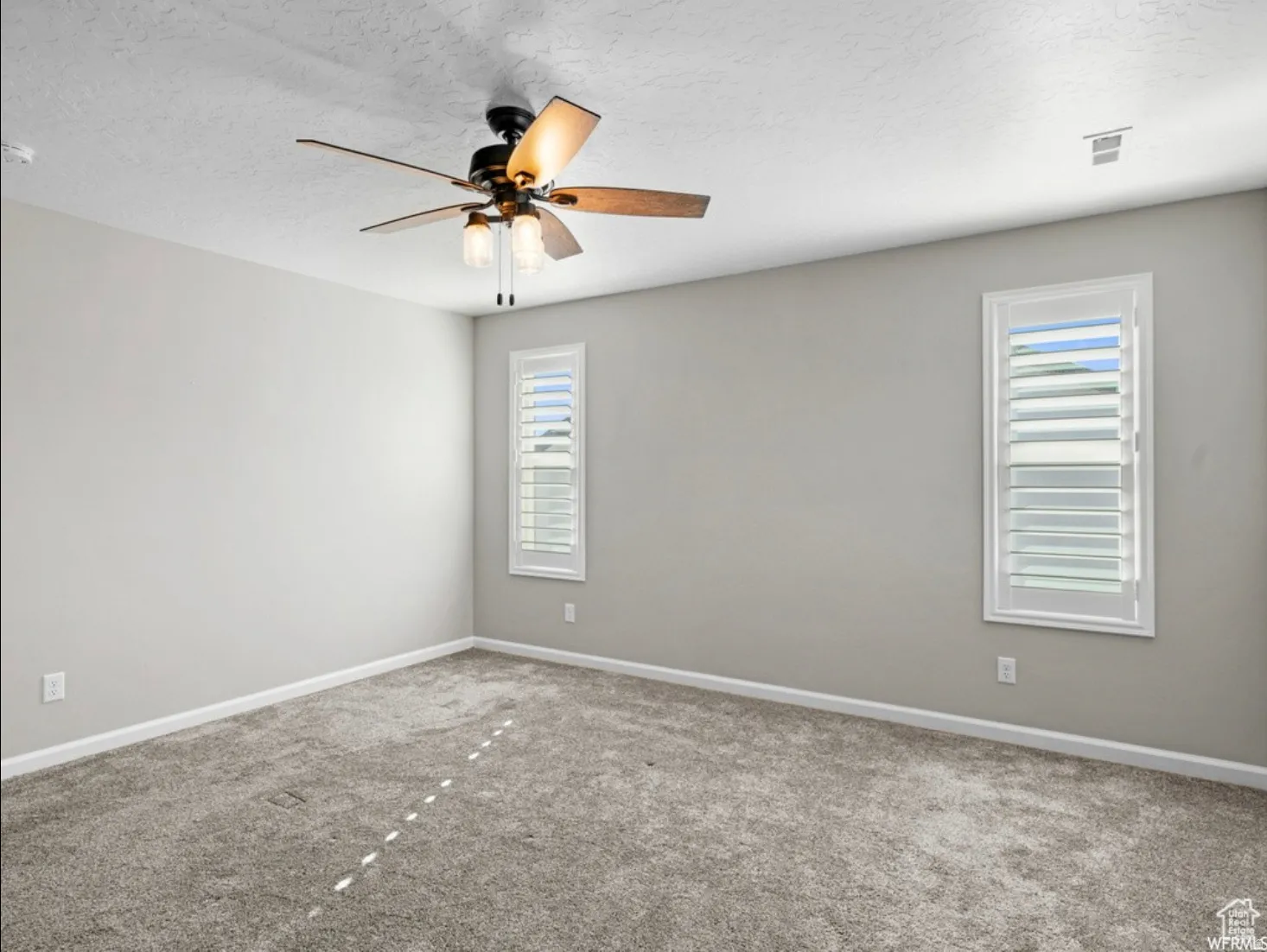 Spacious room featuring neutral carpeting and light-toned wall paint
