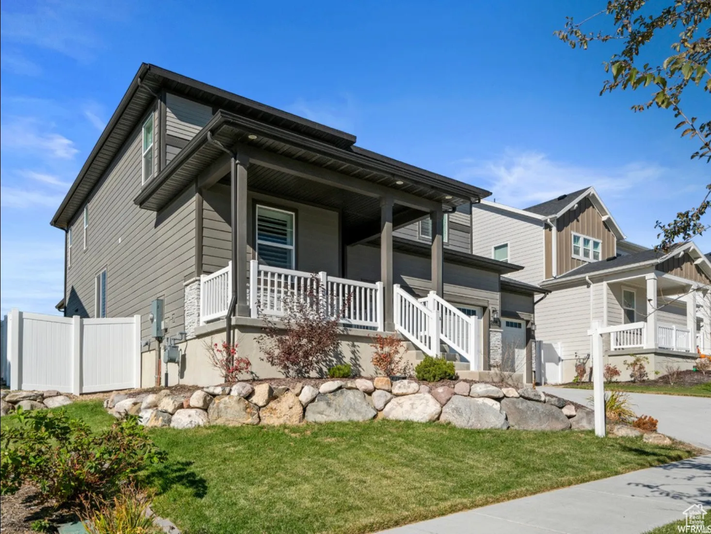 Two-story residence featuring grey horizontal siding and dark trim