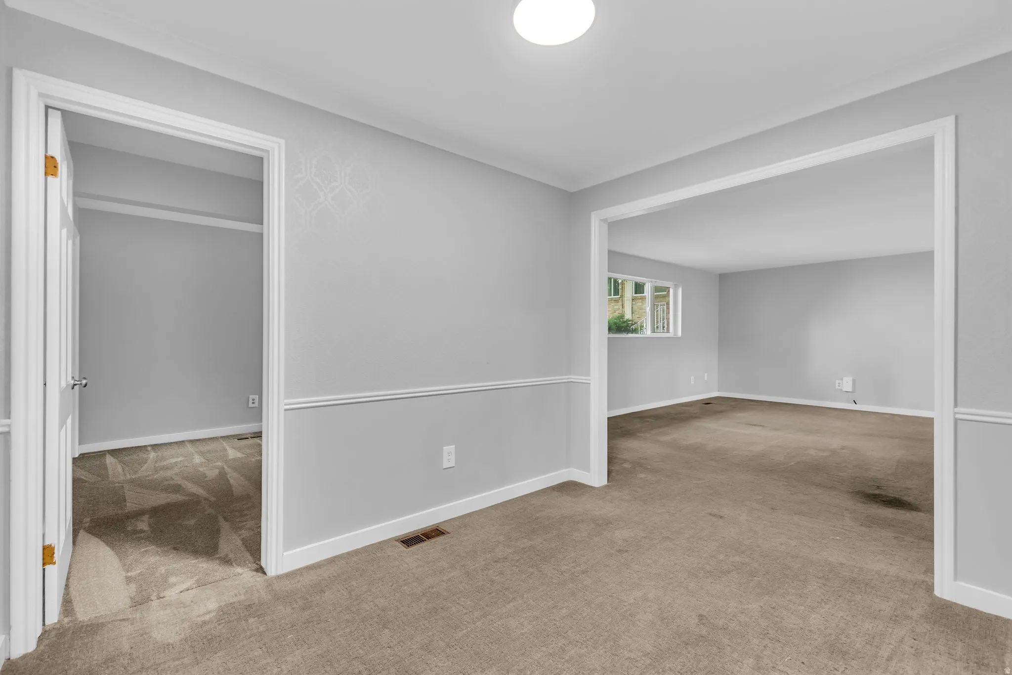 Interior room featuring light gray walls with chair rail molding and geometric accent wallpaper