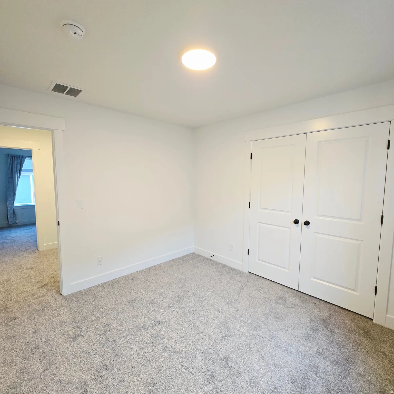 Neutral-toned wall-to-wall carpeting and bright white walls
