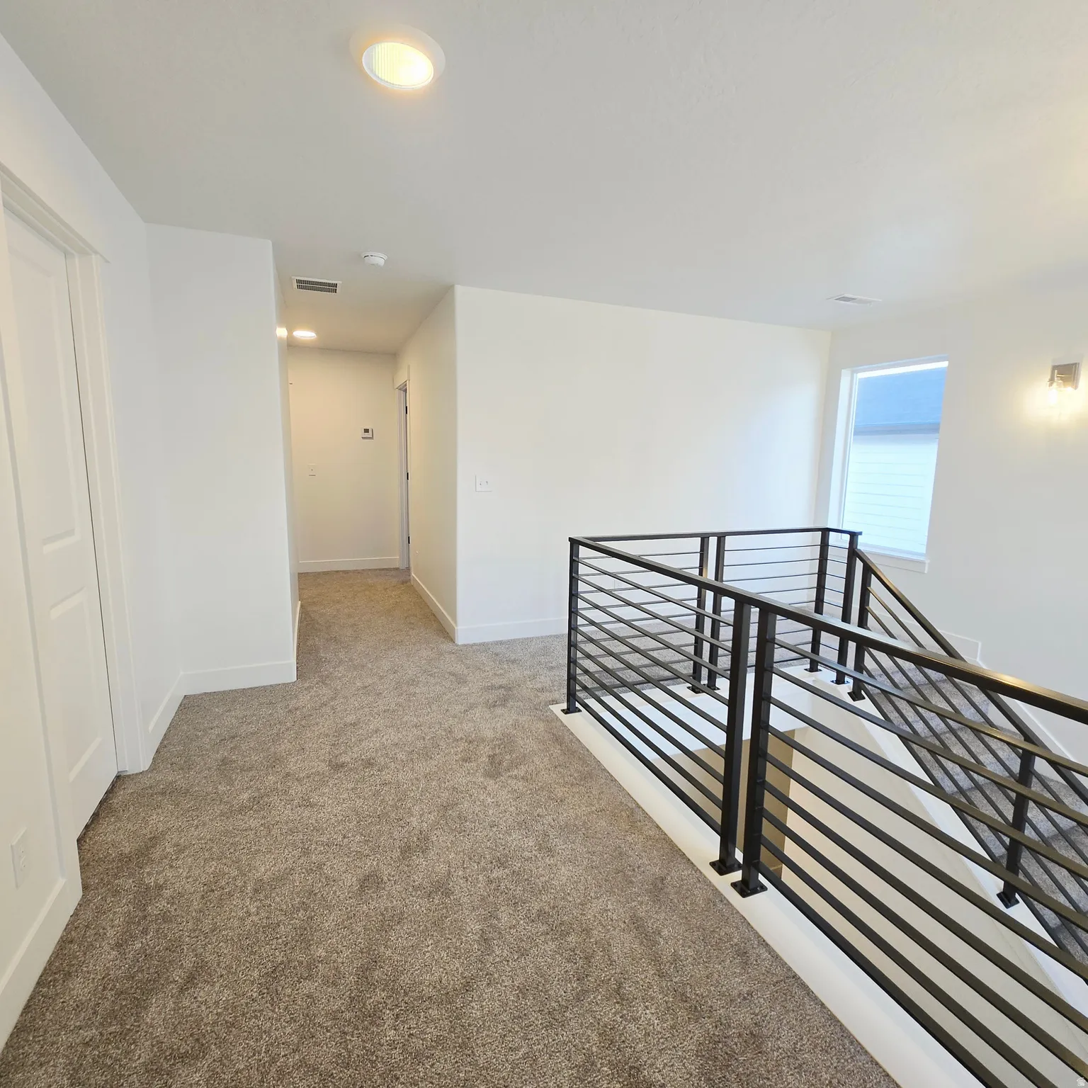 Modern stair railing with horizontal metal balusters and black posts