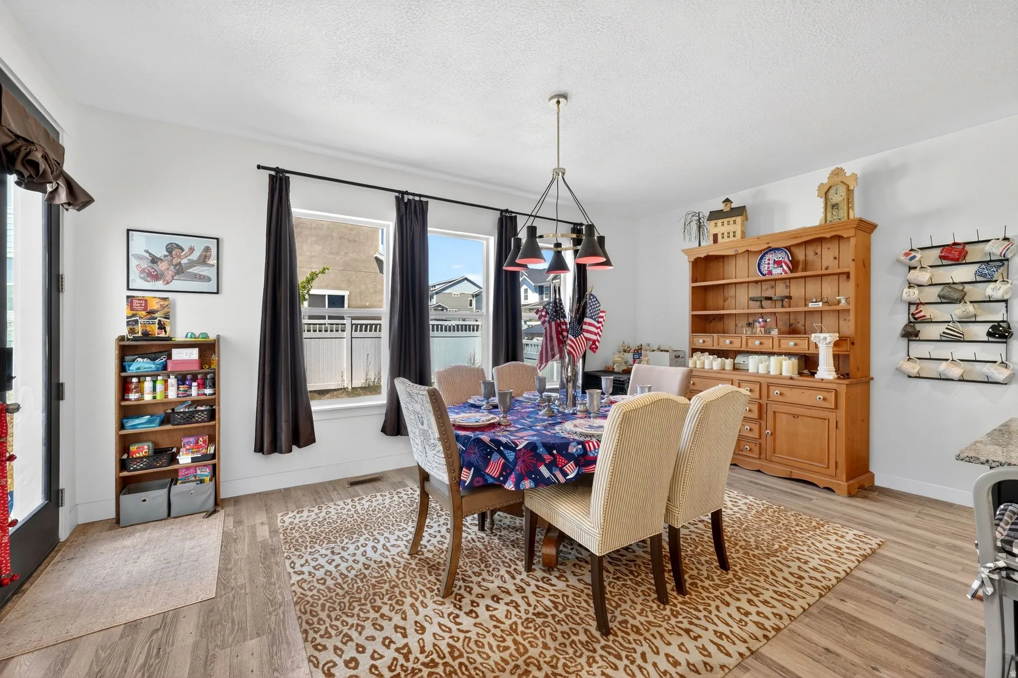 Dining area featuring wood-finish flooring, white walls, and a multi-light pendant fixture