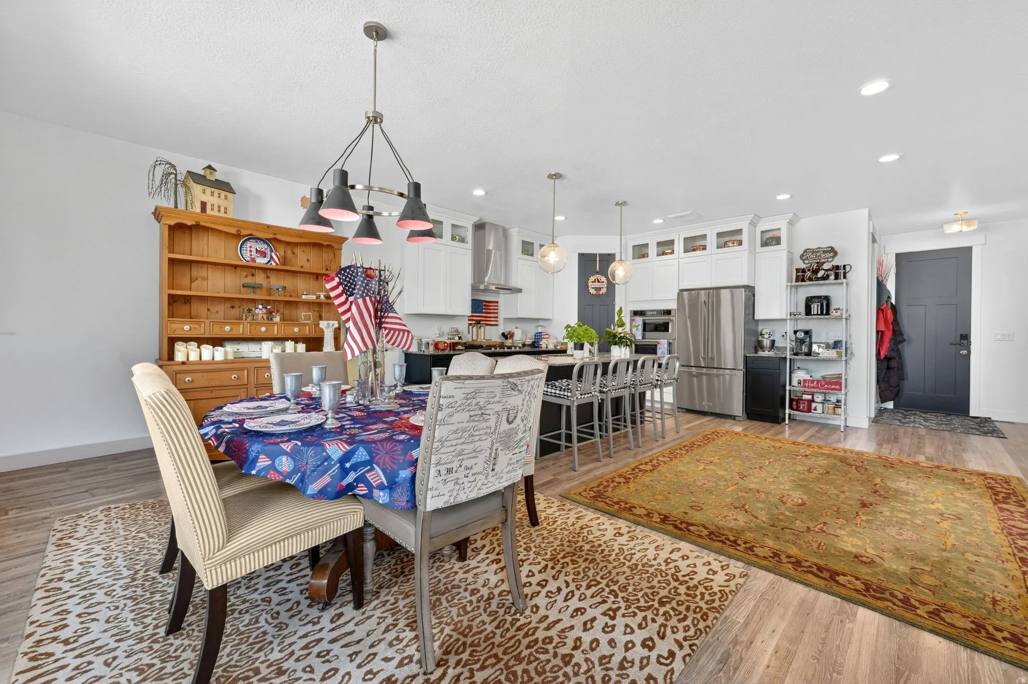Open-concept living space featuring wood-finish flooring, recessed lighting, and a modern chandelier