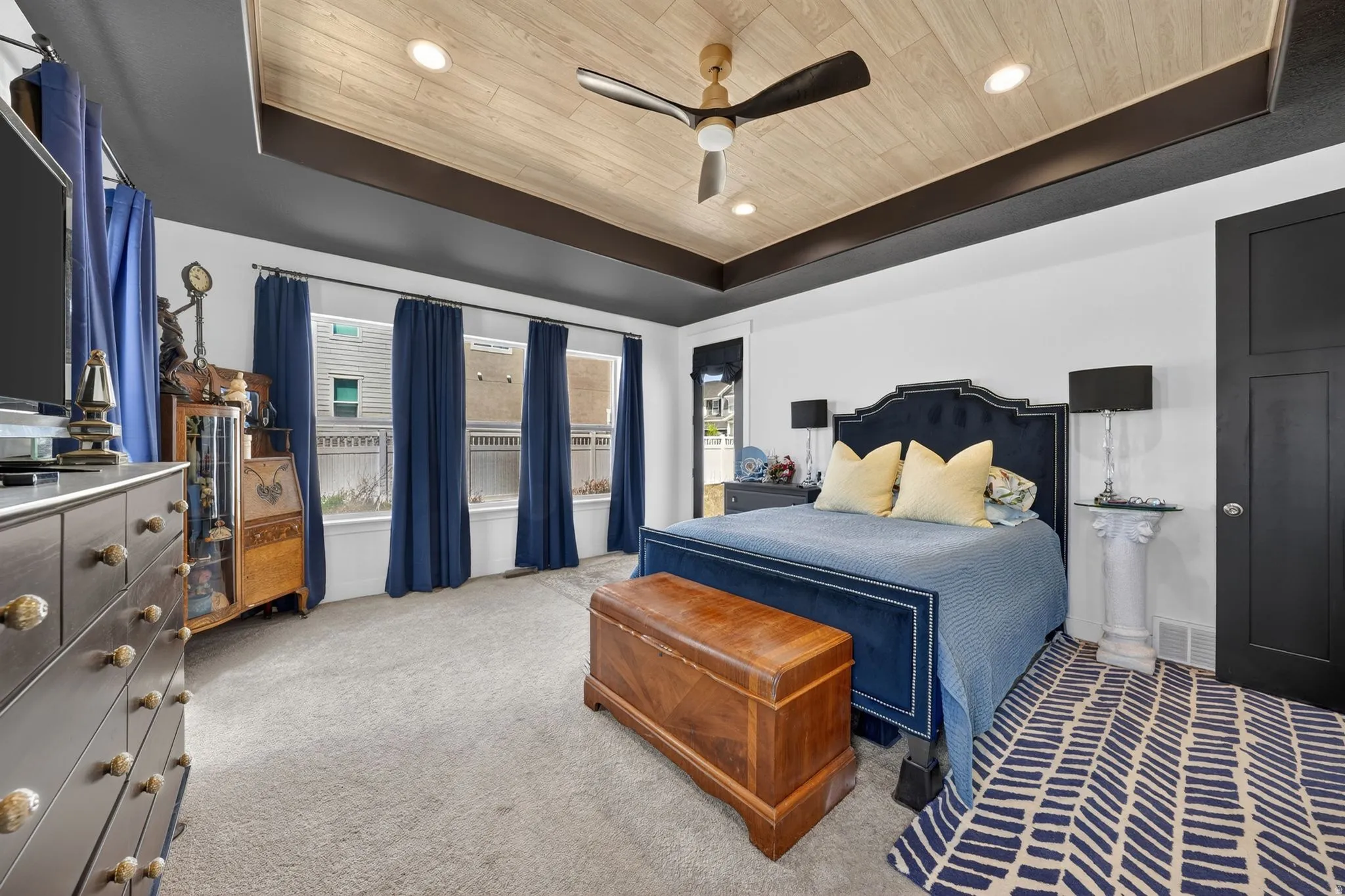 Recessed lighting illuminates a ceiling with a wood-finish accent and dark beams