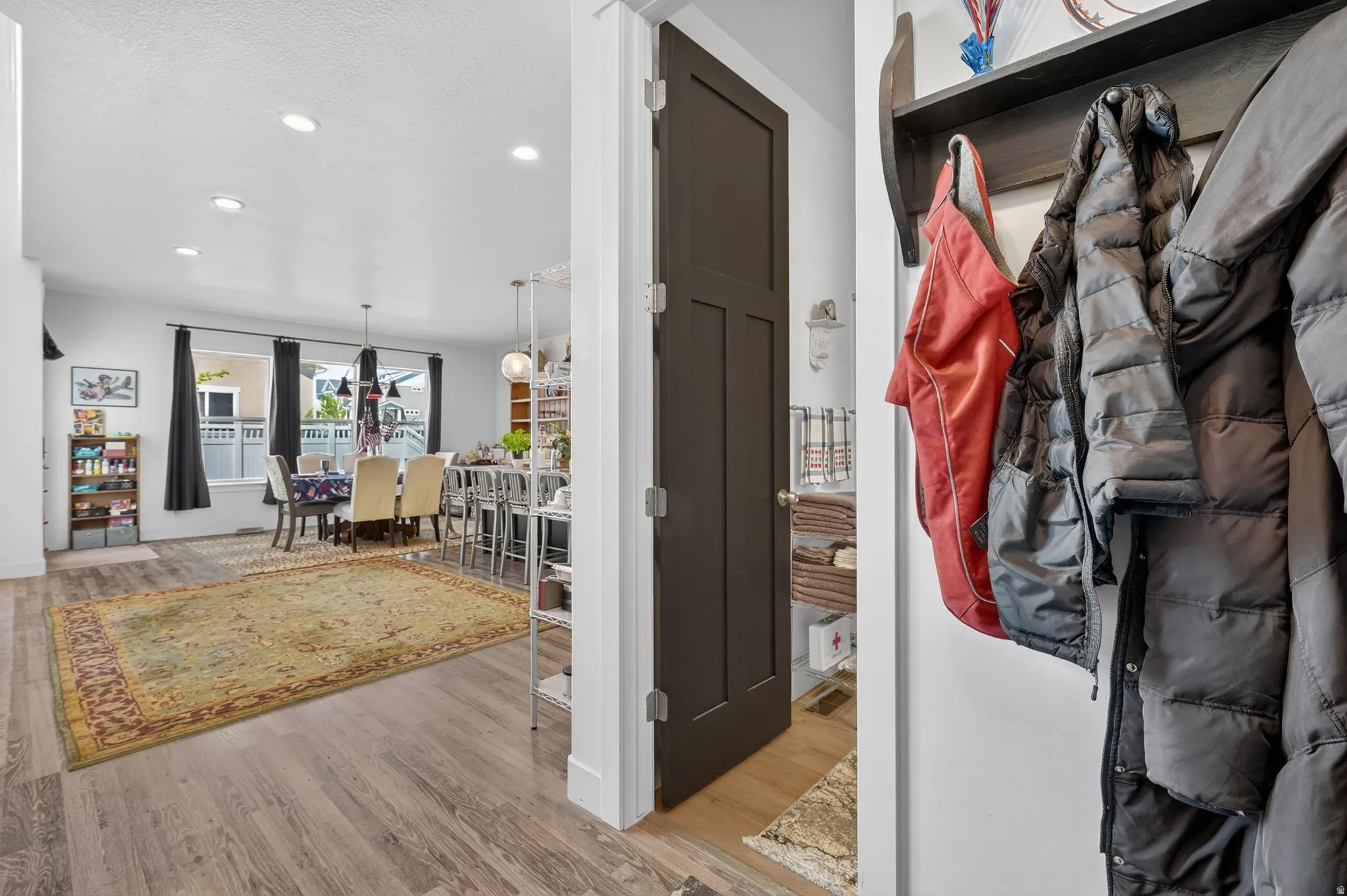 Open-concept living area featuring wood-finish flooring, recessed lighting, and a dining space with pendant fixtures