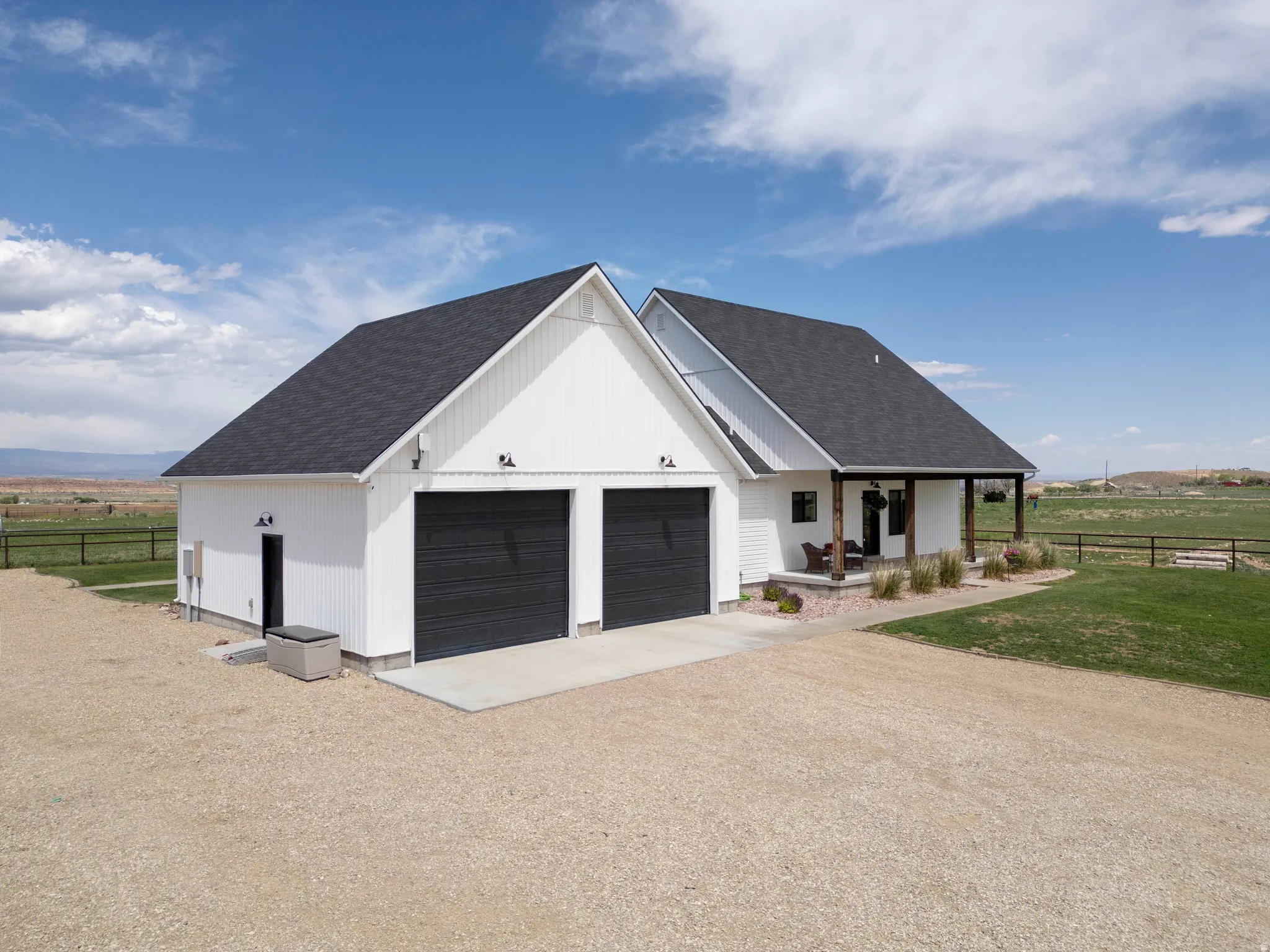 Modern farmhouse exterior with a dark shingle roof and white vertical siding