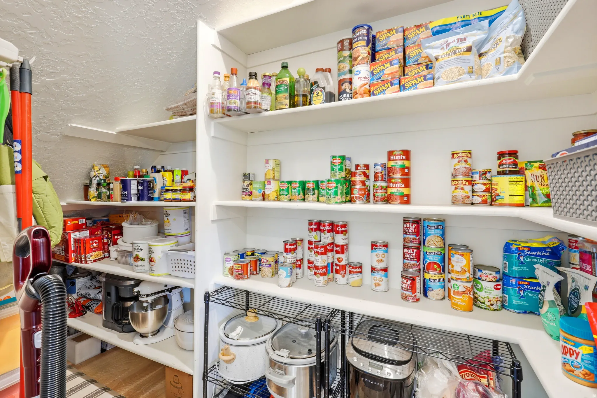 Expansive pantry featuring multiple levels of built-in shelving, durable wire shelving, and bright white finishes