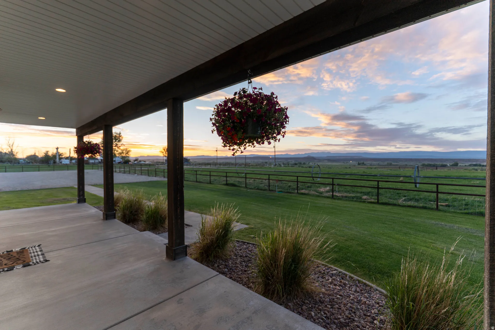Covered patio with integrated lighting, concrete flooring, and dark-stained support beams