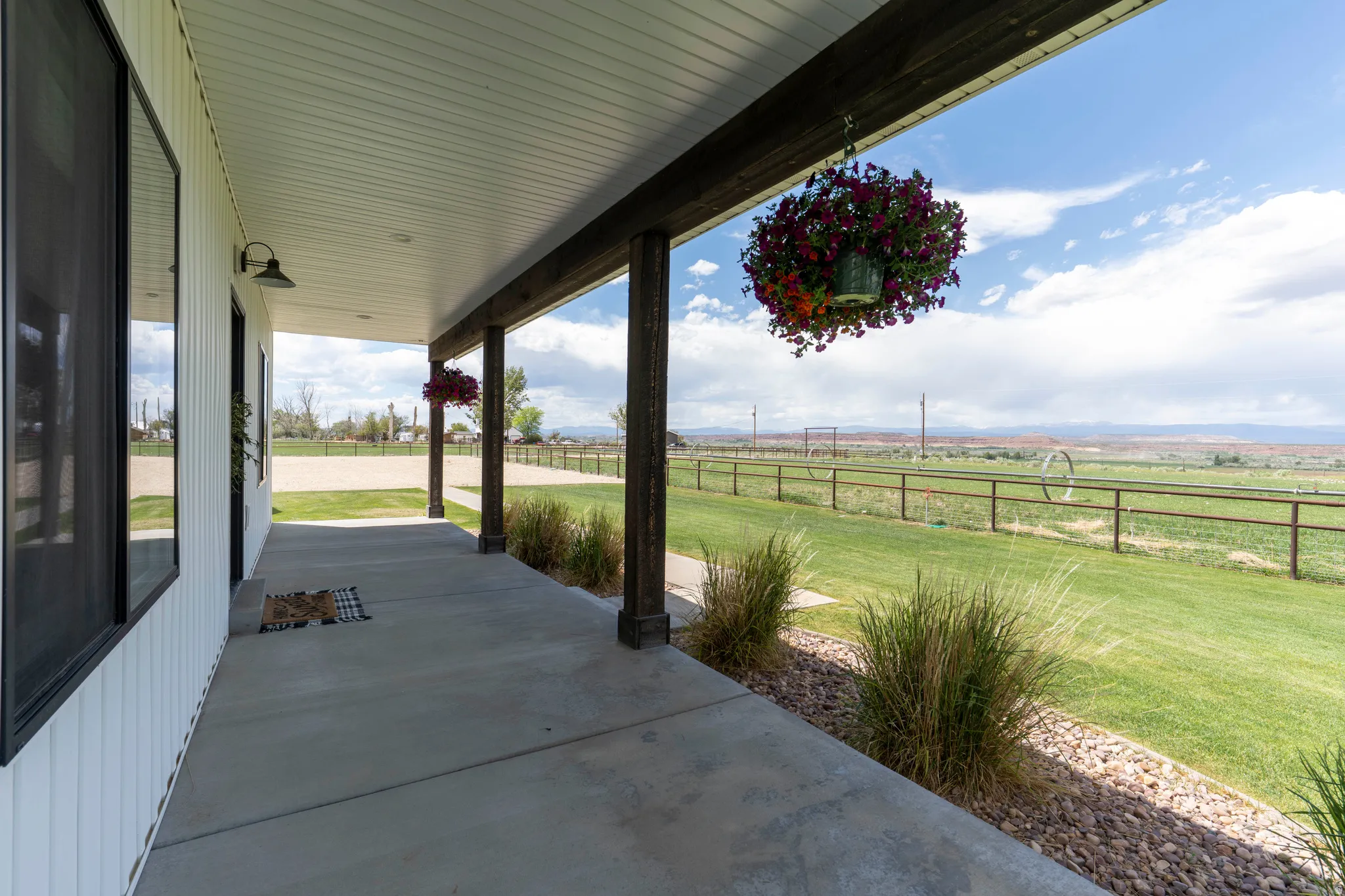 Covered concrete patio featuring dark wood-finish support beams and a white soffit ceiling