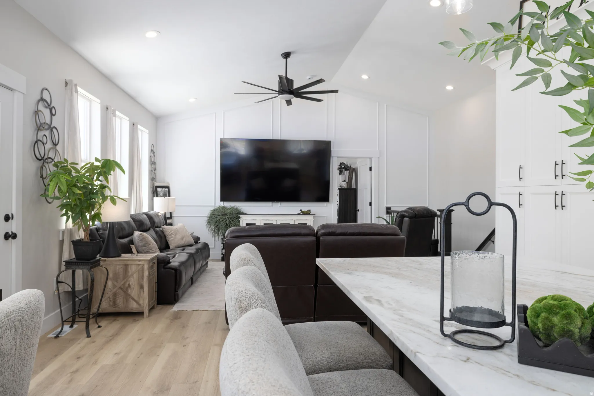 Open-concept living space featuring wood-finish flooring, recessed lighting, and a vaulted ceiling with a ceiling fan