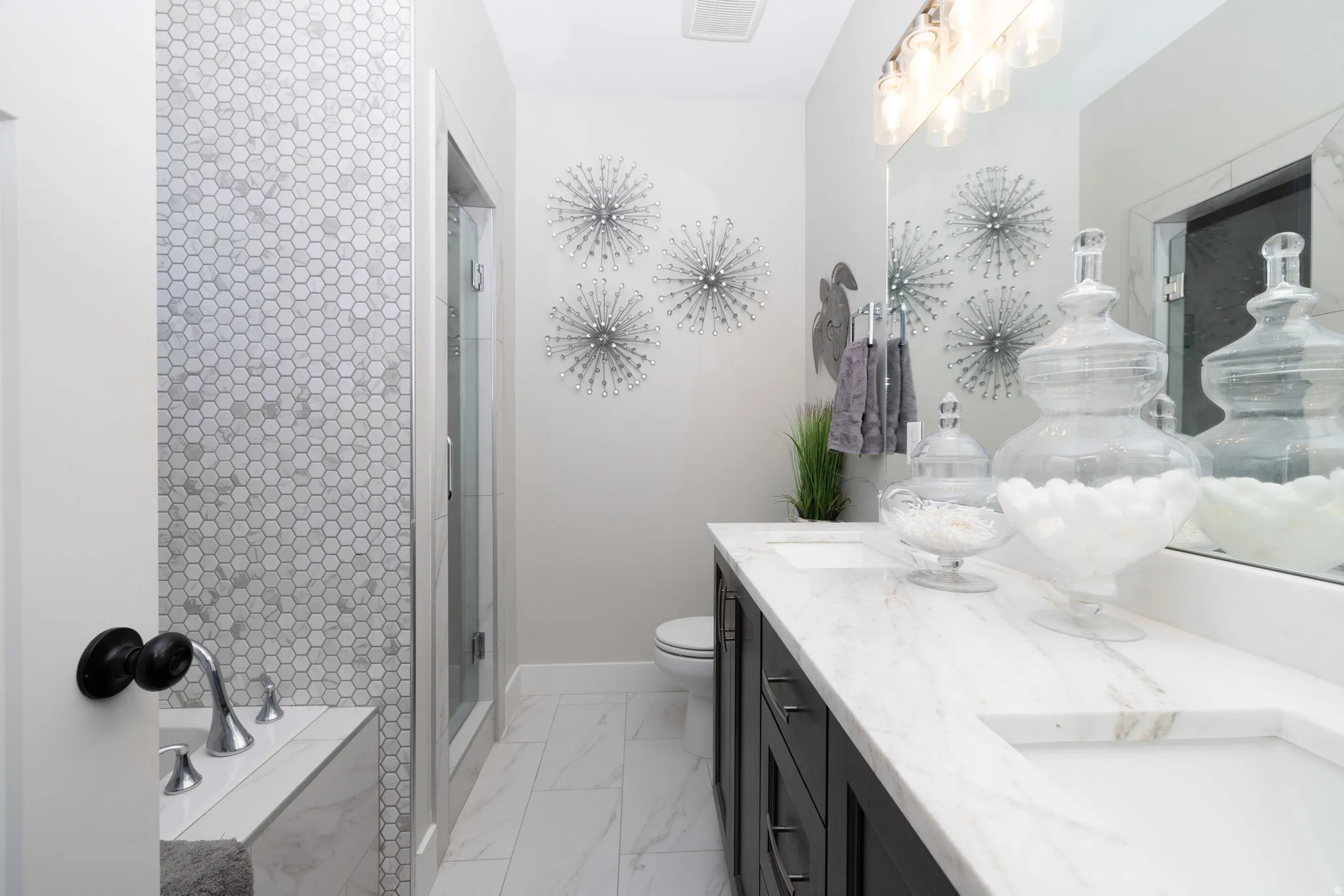 Primary Suite featuring a double vanity with granite countertops, integrated rectangular sinks, and dark wood-finish cabinetry