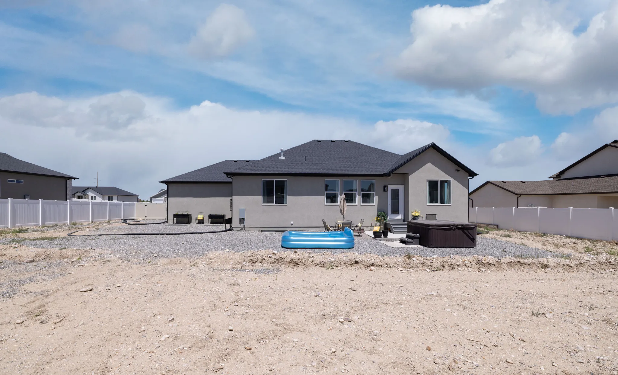 Spacious backyard featuring a dedicated patio area, exterior entry, and stucco siding