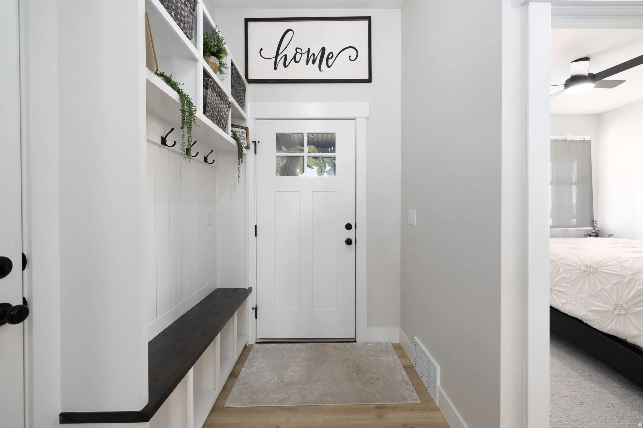 Entryway featuring wood-finish flooring and a built-in bench with storage
