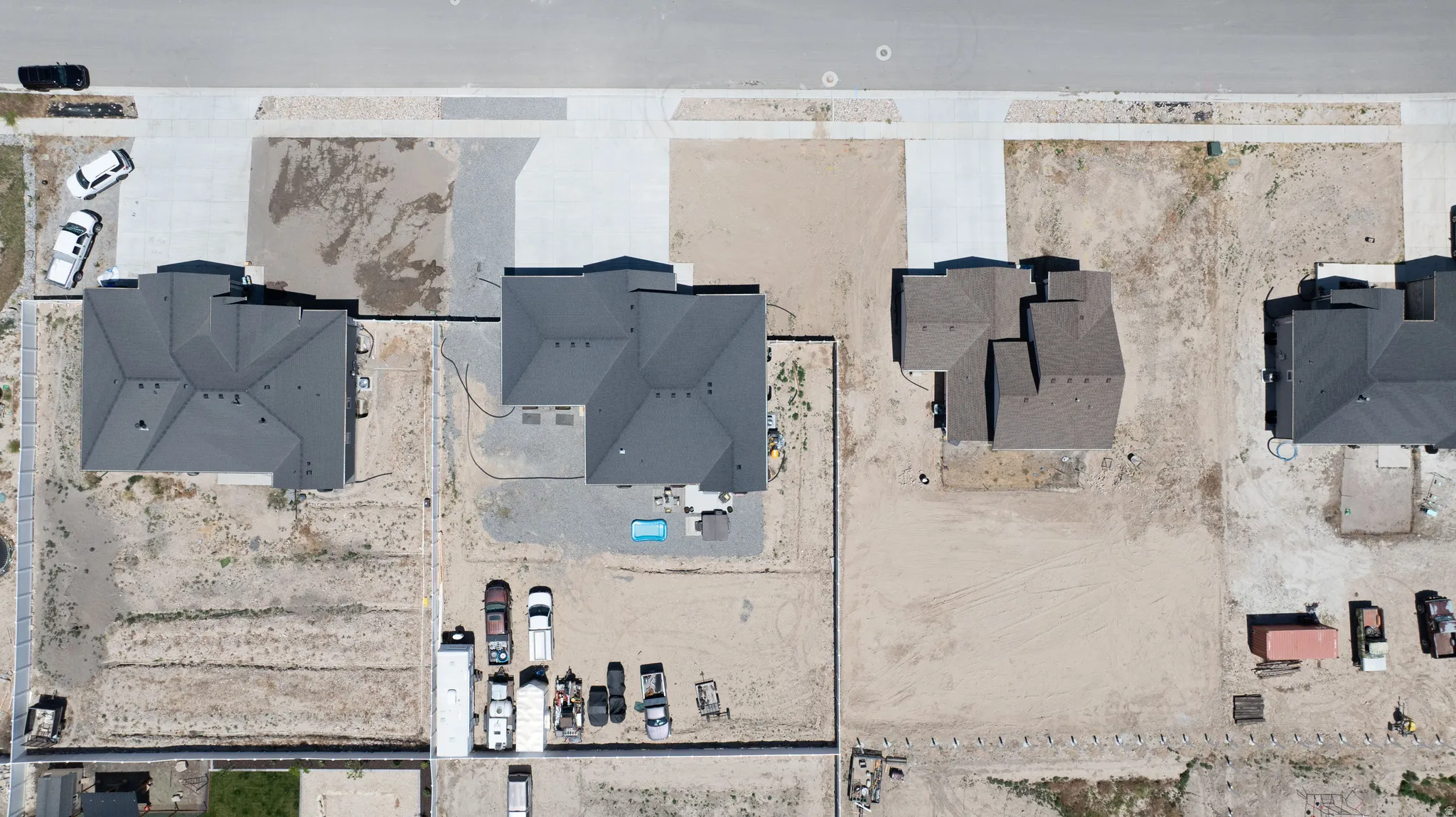New construction homes featuring dark grey shingle roofs and concrete driveways