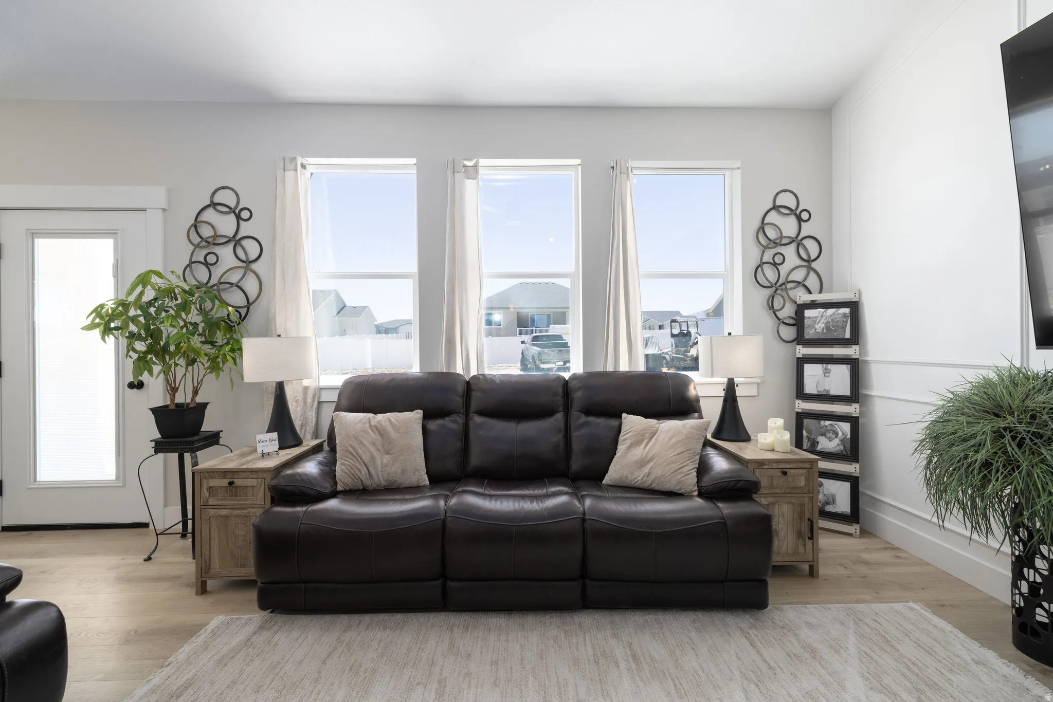 Living area featuring light wood-finish flooring and three large windows