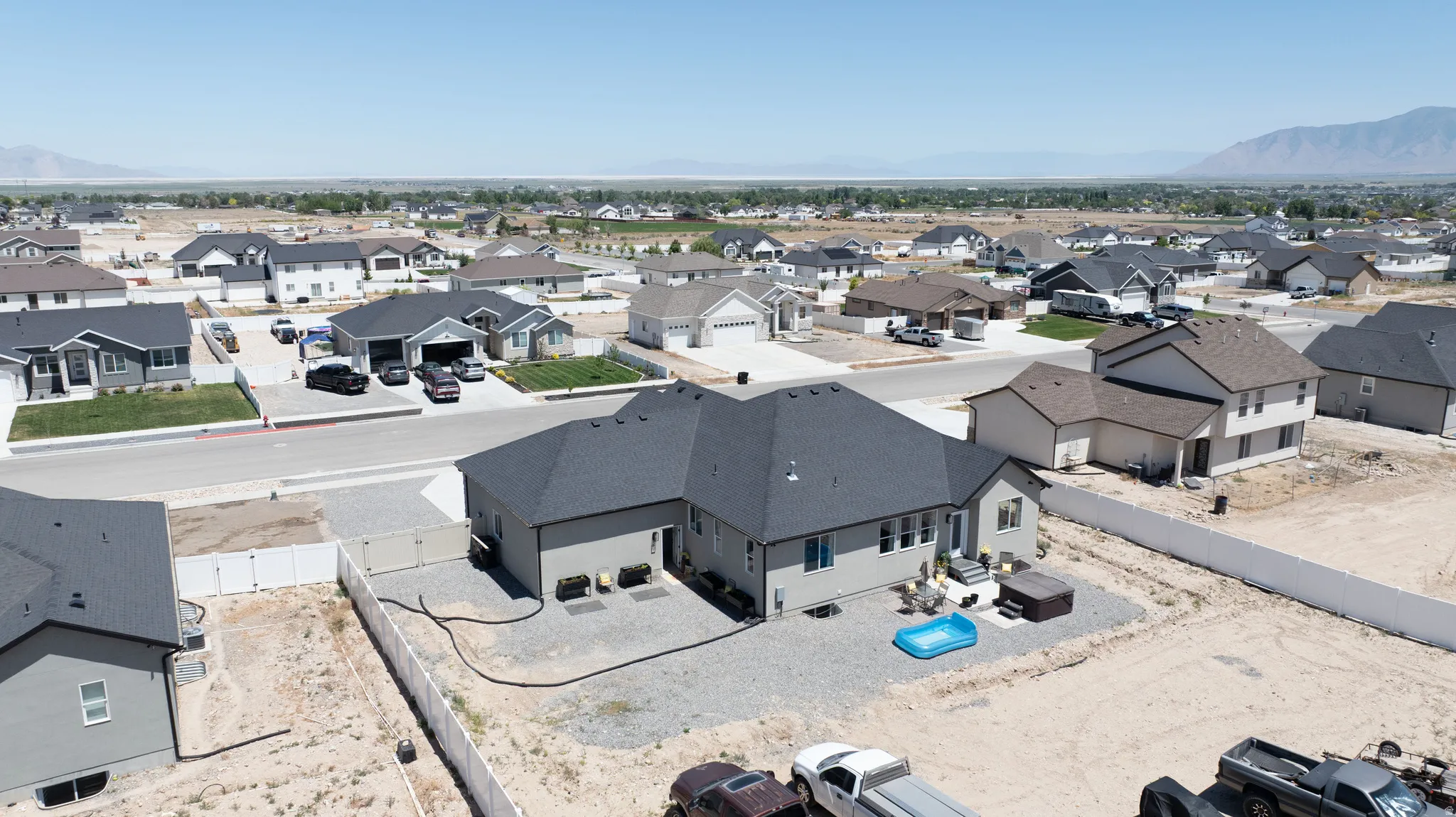Exterior view of a single-story residence featuring a dark gray roof and light gray siding