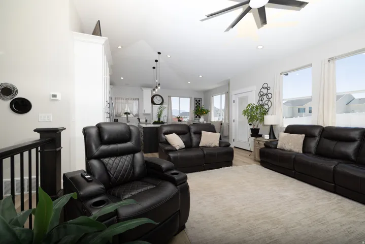 Open-concept living space featuring wood-finish flooring, recessed lighting, and a contemporary ceiling fan